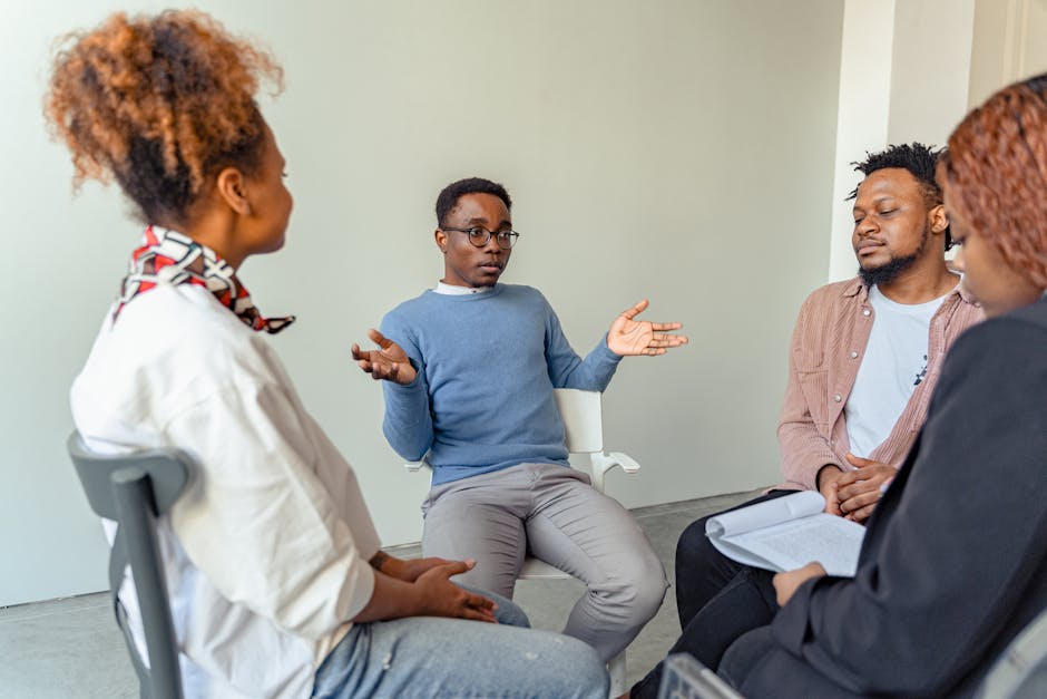 pexels-photo-7579310-7579310 Diverse group therapy session with young adults and a mental health professional indoors.